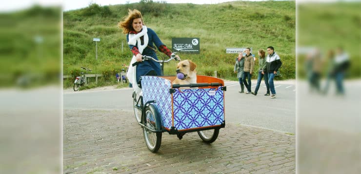 Frauchen und Hund mit Lastenrad am Strand