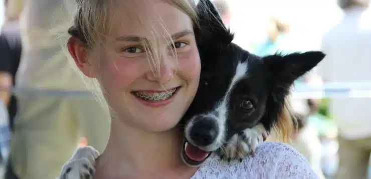 Mädchen und Hund schauen in die Kamera