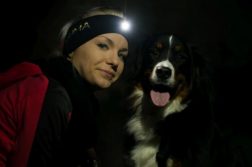 LUMA Enlite: Clevere Beleuchtungsidee für Herrchen und Hund Frau und Hund schauen in Kamera. Die Frau trägt ein Stirnband mit LED-Lampe