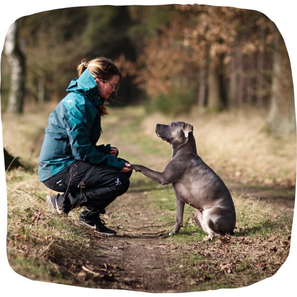 Alexa und Hündin Gracie auf einem Waldweg, Gracie gibt ihre linke Pfote