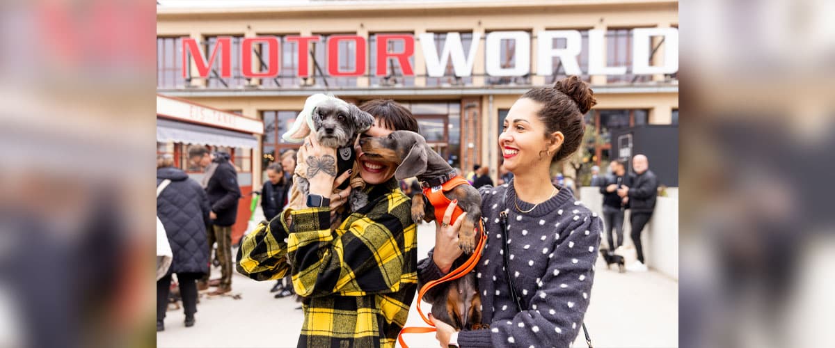 Zwei Besucherinnen mit ihren Hunden vor dem Eingang der Motorworld München bei der DogWorld Messe.