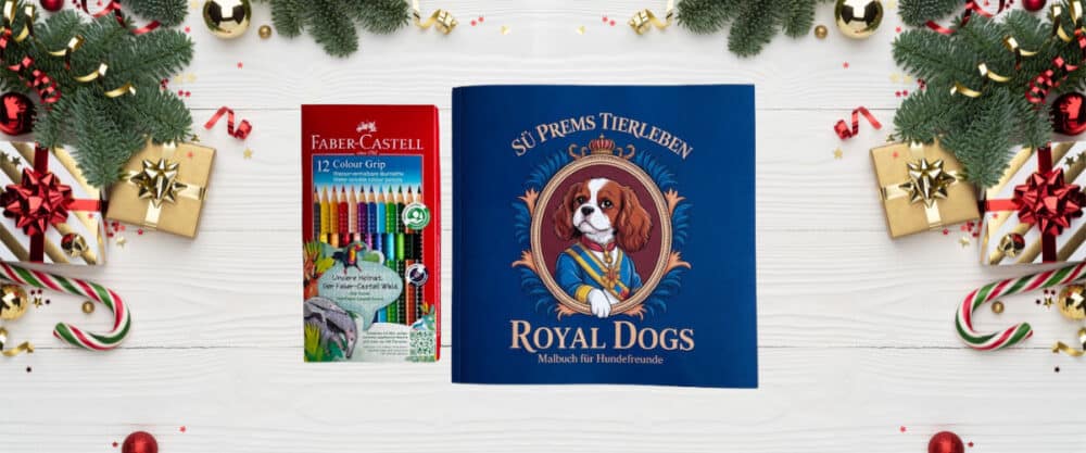 Malbuch "Royal Dogs" für Hundefreunde und ein Set Buntstifte, weihnachtlich dekoriert mit Tannenzweigen und Geschenken.