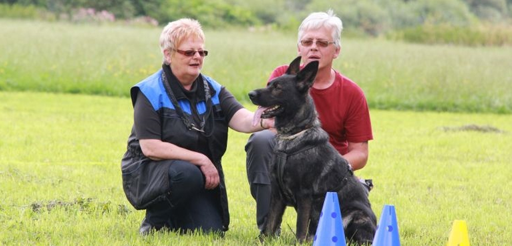 Michael und Petra Trübger mit ihrer Schäferhündin Laika auf einer Wiese