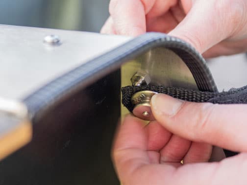 Gurtband mit Druckknopf an Wand der Lastenradbox fixiert
